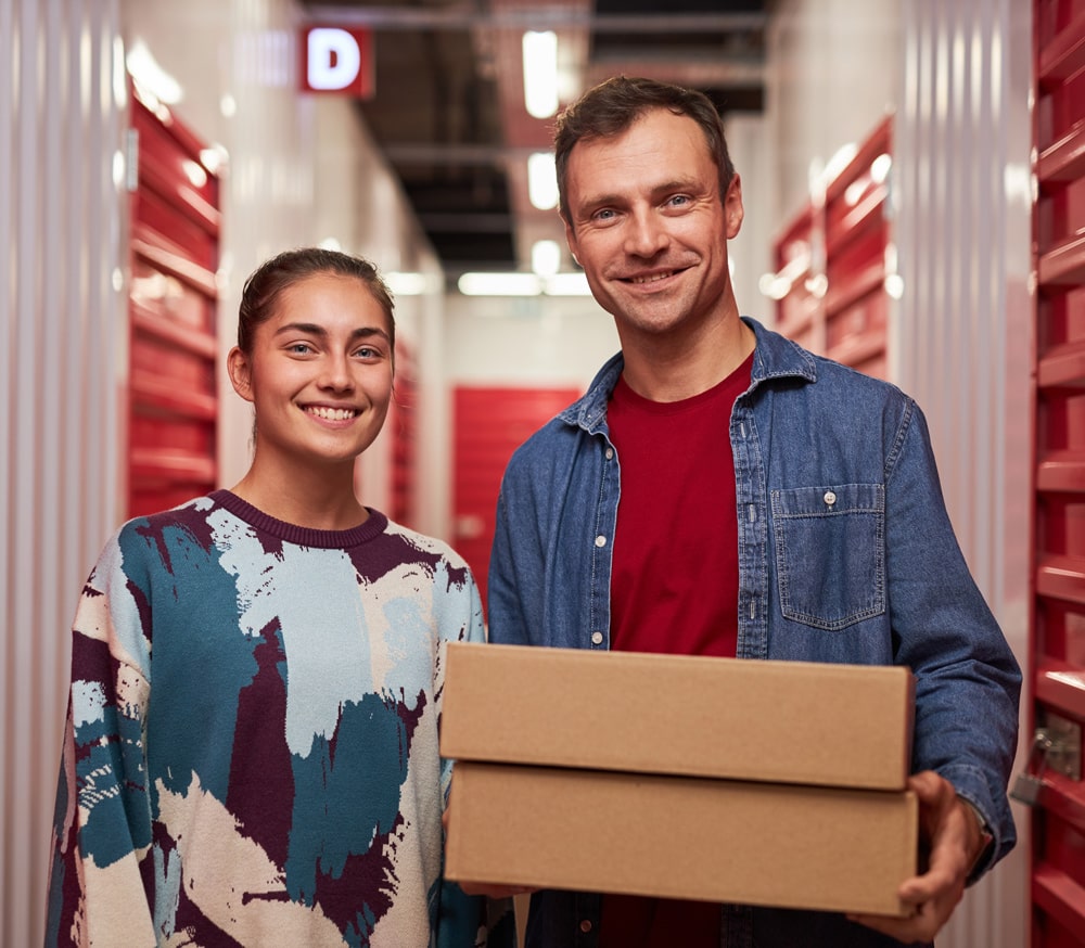 happy-couple-standing-in-corridor-of-self-storage-facility-unit